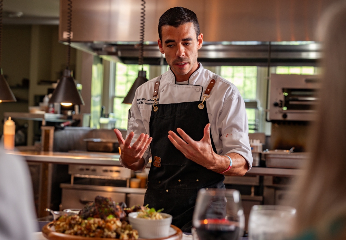 https://edgeofgalena.com/images/carousel/goldmoor-inn-chef-preparing-guests-engaging-with-chef-as-he-prepares-course.jpg