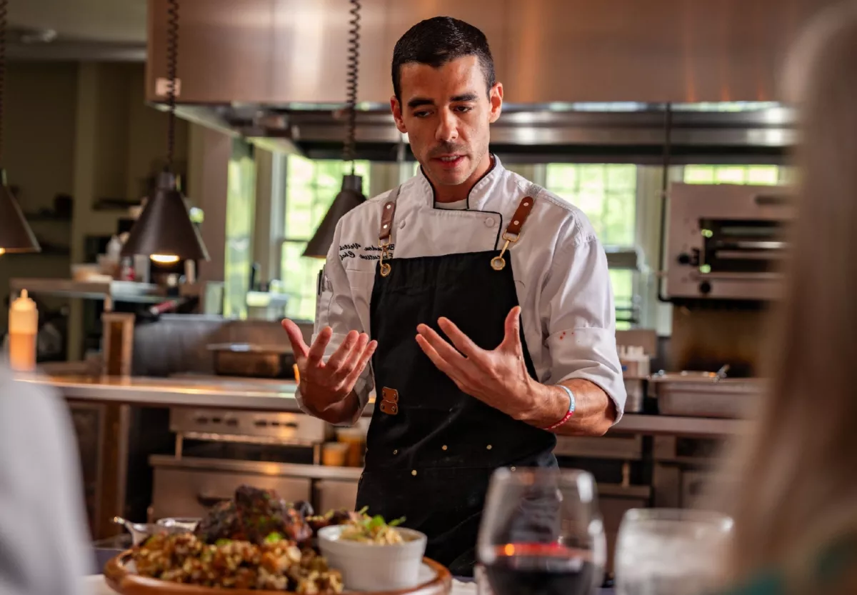 https://edgeofgalena.com/images/carousel/goldmoor-inn-chef-preparing-guests-engaging-with-chef-as-he-prepares-course.jpg